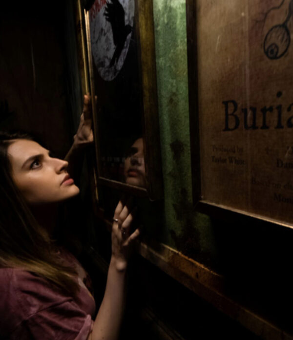 Girl finding a clue in The Other Side escape room at Fox in a Box Adelaide, surrounded by supernatural-themed props.